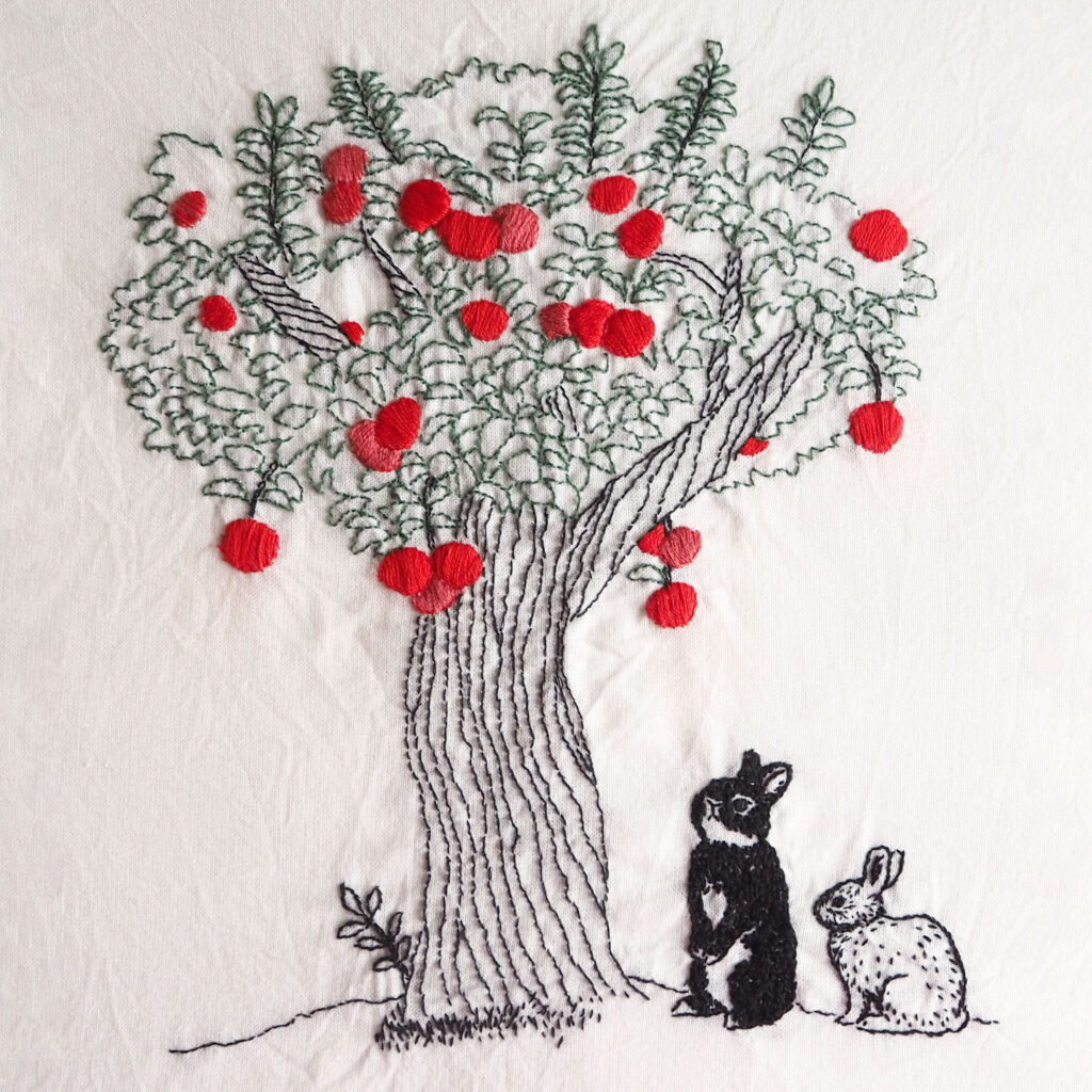 りんごの木を見つめるうさぎの刺繍作品