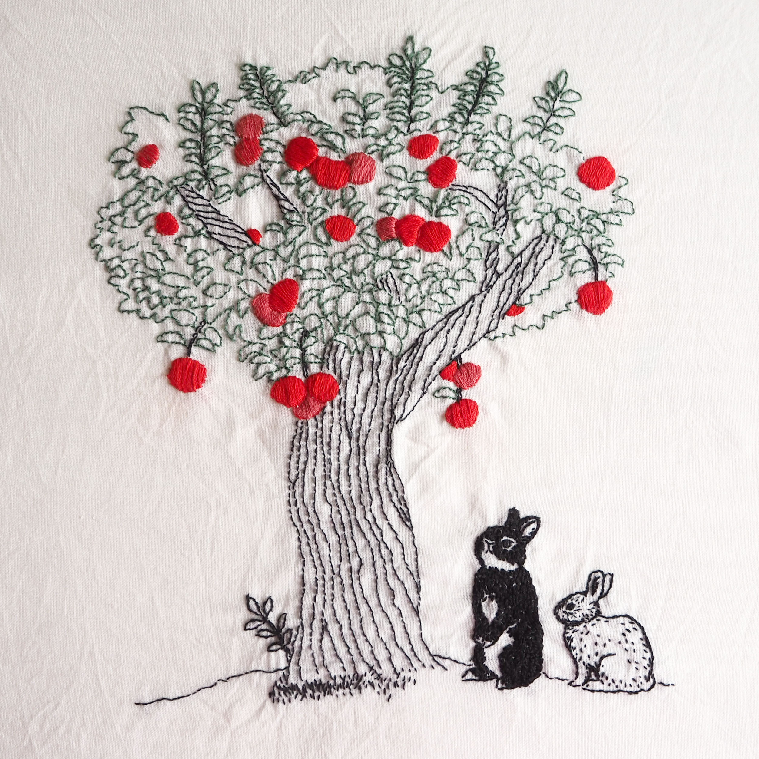 リンゴの木を見つめるうさぎの刺繍作品